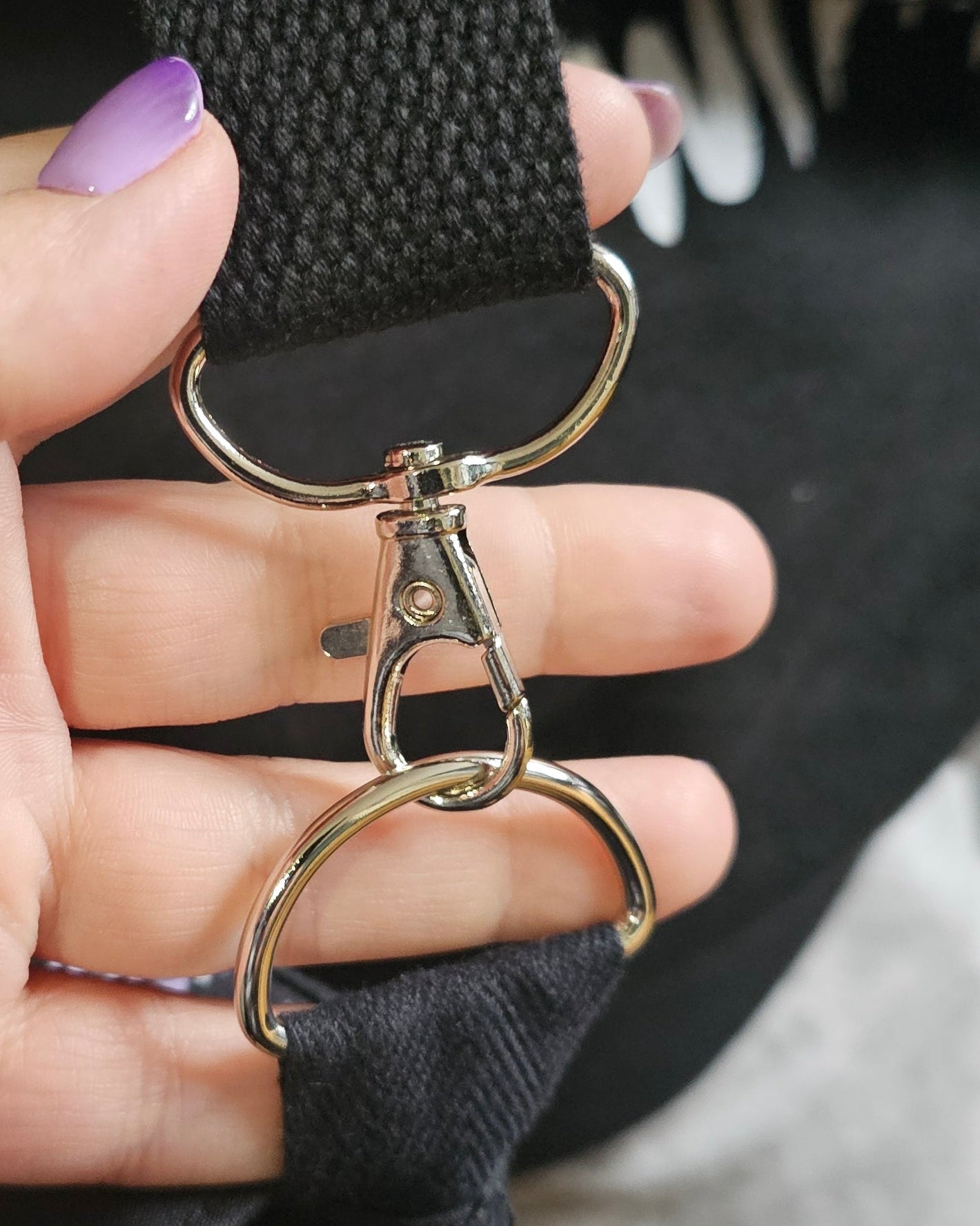 Close up of a hand holding stainless steel bag hardware 
