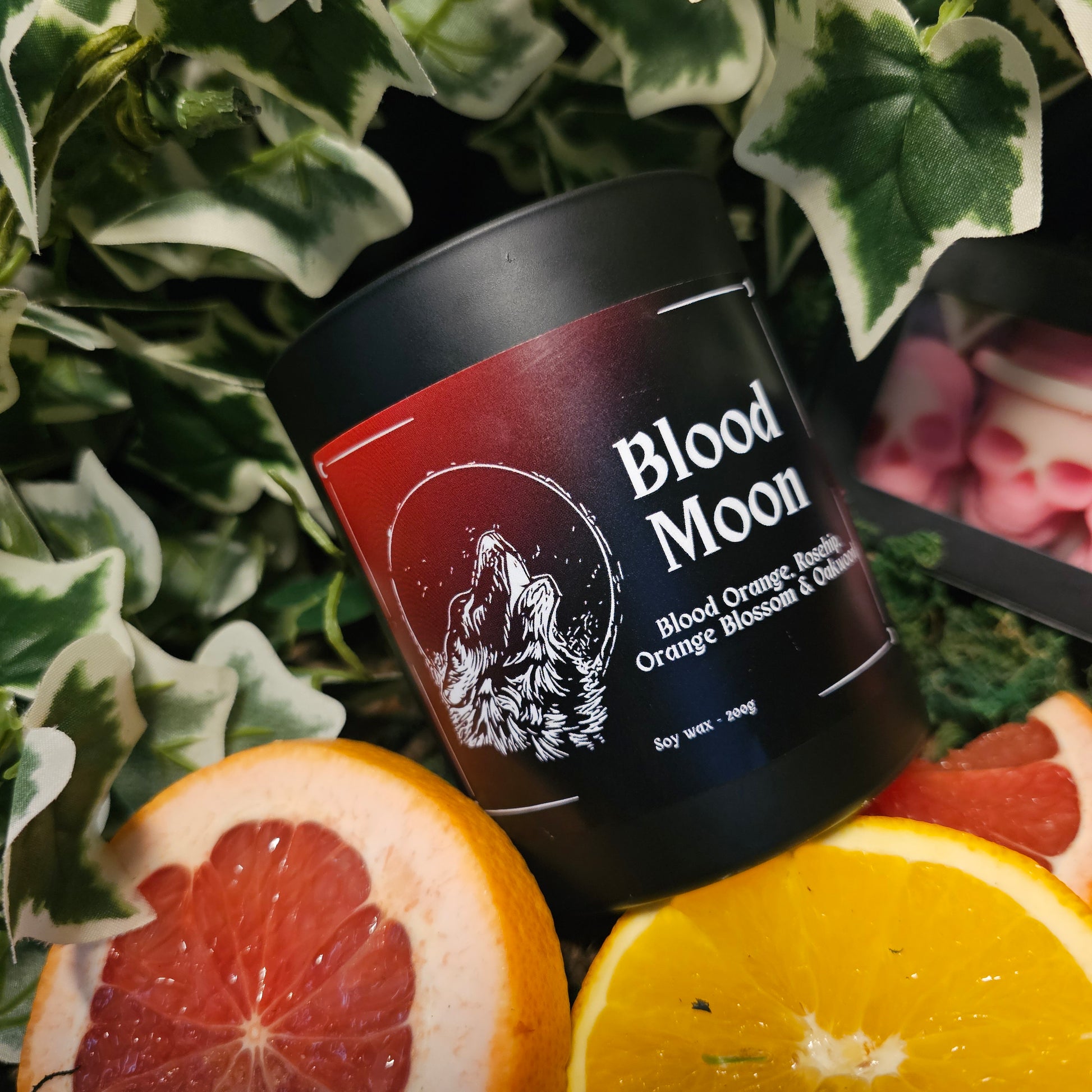 Bloodmoon candle on a background of moss and ivy 