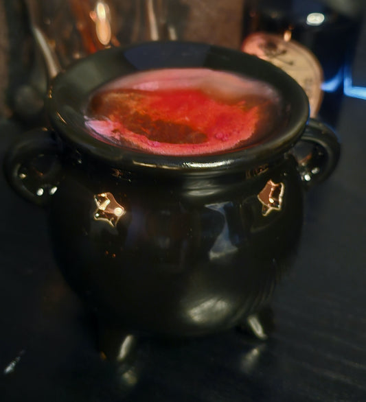 Black cauldron with red liquid on a dark background