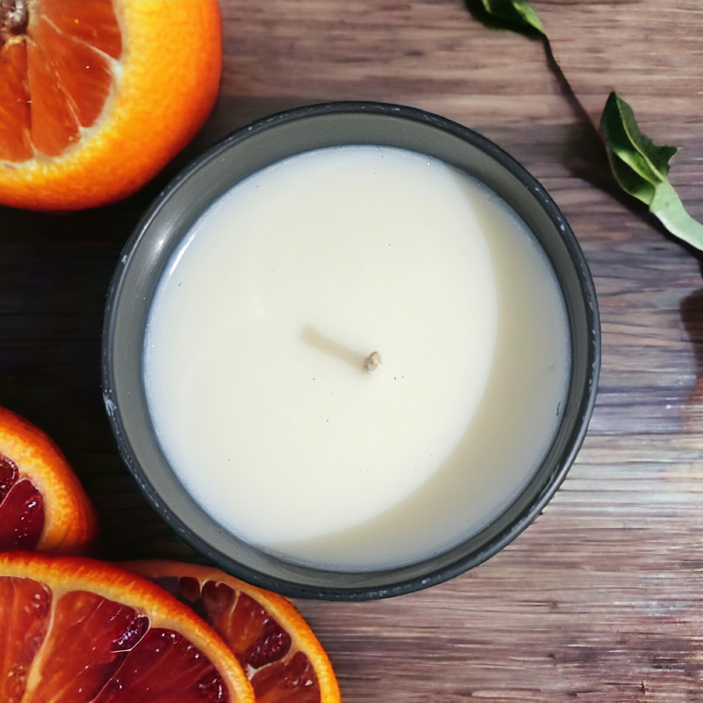 a candle photographed from above with blood orange beside it 