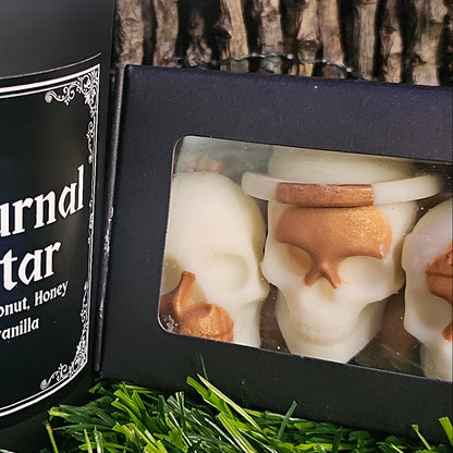 Black box with window displaying white and brown skull-shaped wax melts, 