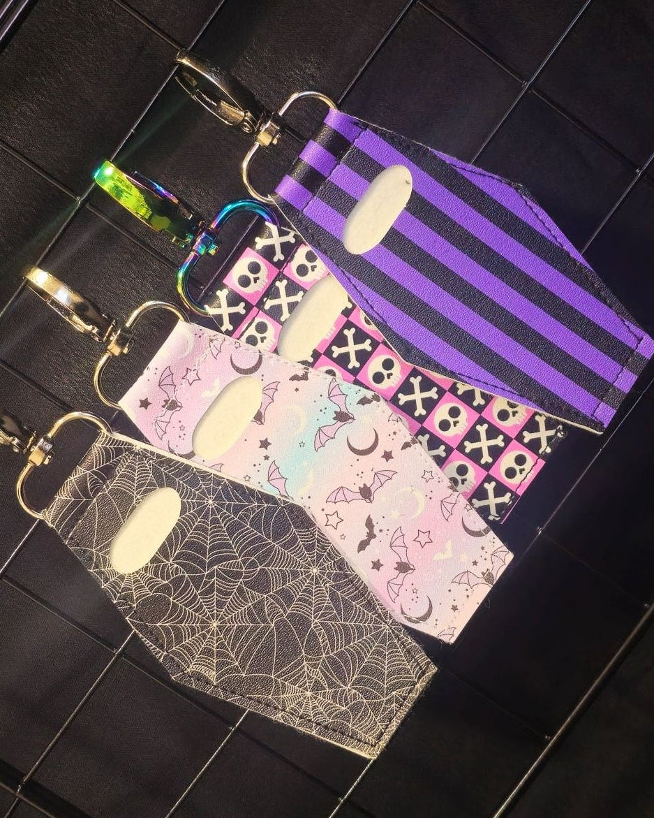 Coffin-shaped lip gloss holder keychain. Leatherette with stainless steel lobster clasp multiple designs shown 