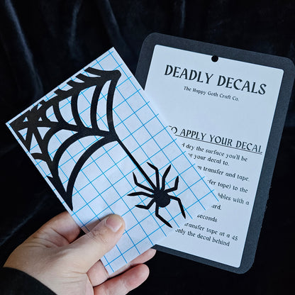 A had holding a not yet applied decal and aplication instructions, against a black background 