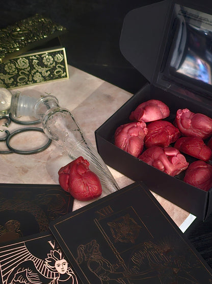 A box of heart shaped wax melts surrounded with tarot cards and spiritual orniments 