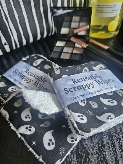 Reusable Scrappy Wipes with ghost pattern on a dark surface with makeup items.