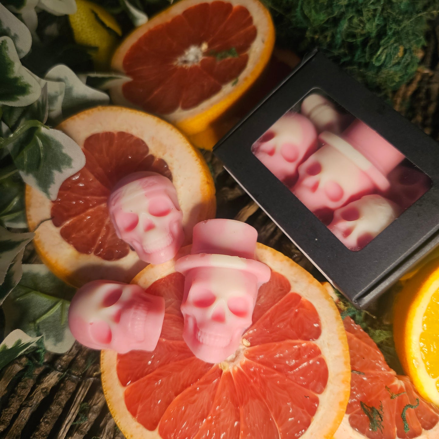 3 pink skull shaped wax melts Laying on top of blood orange slices 