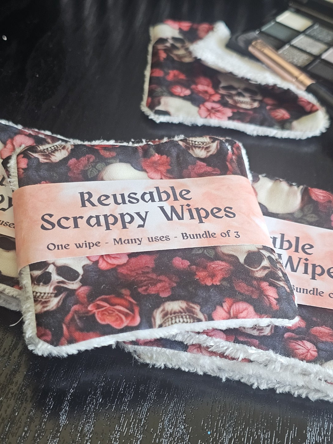 Reusable scrappy wipes / reusable makeup wipes with skull and rose pattern and visible brand label on a dark background