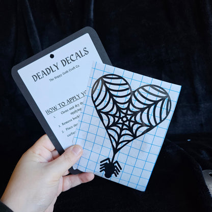 A had holding a not yet applied decal and aplication instructions, against a black background 