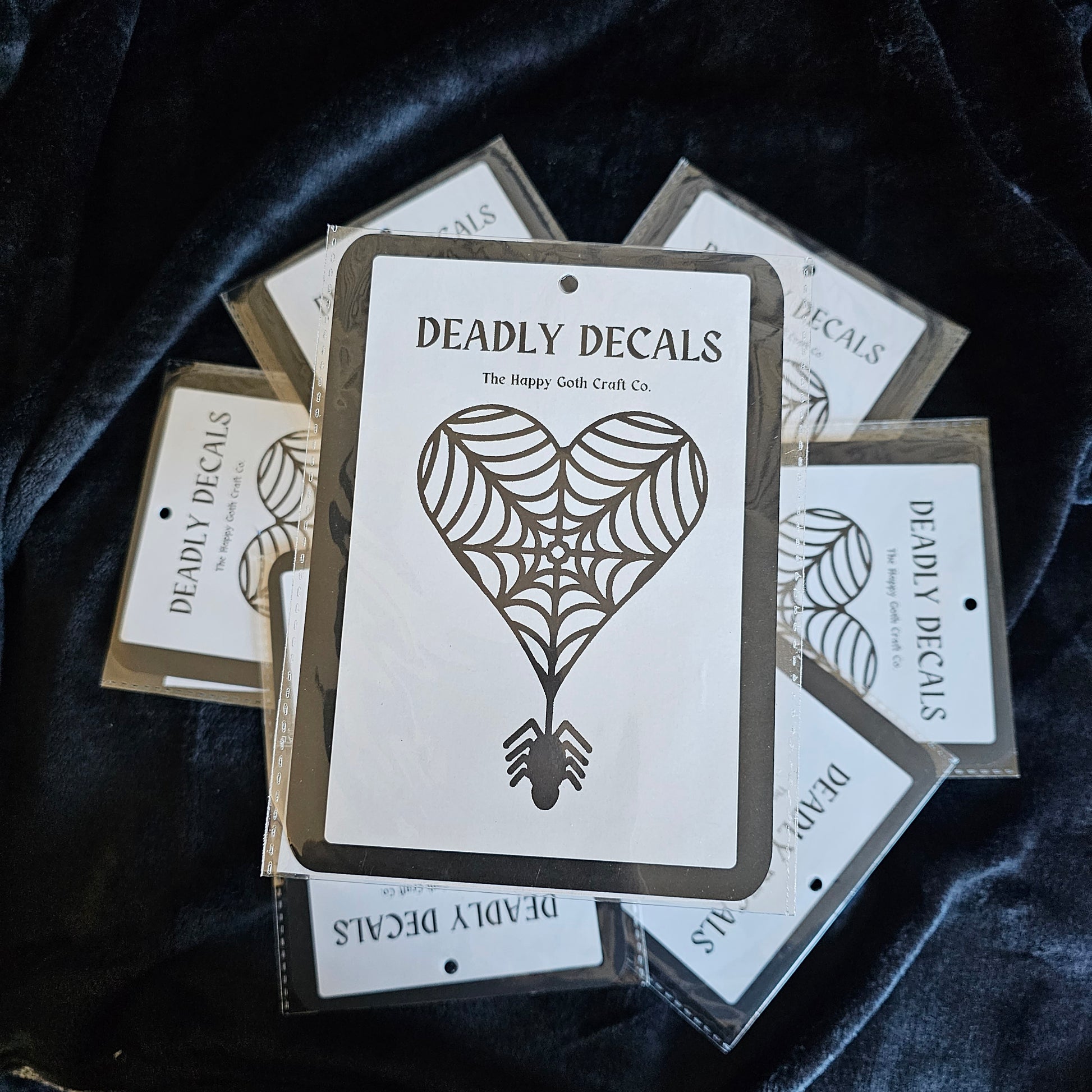 Heart shaped Decal in its packaging displayed on top of a pile of other decals 