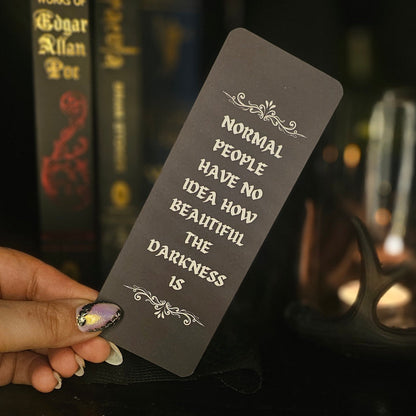 Bookmark with text held by a hand in front of books