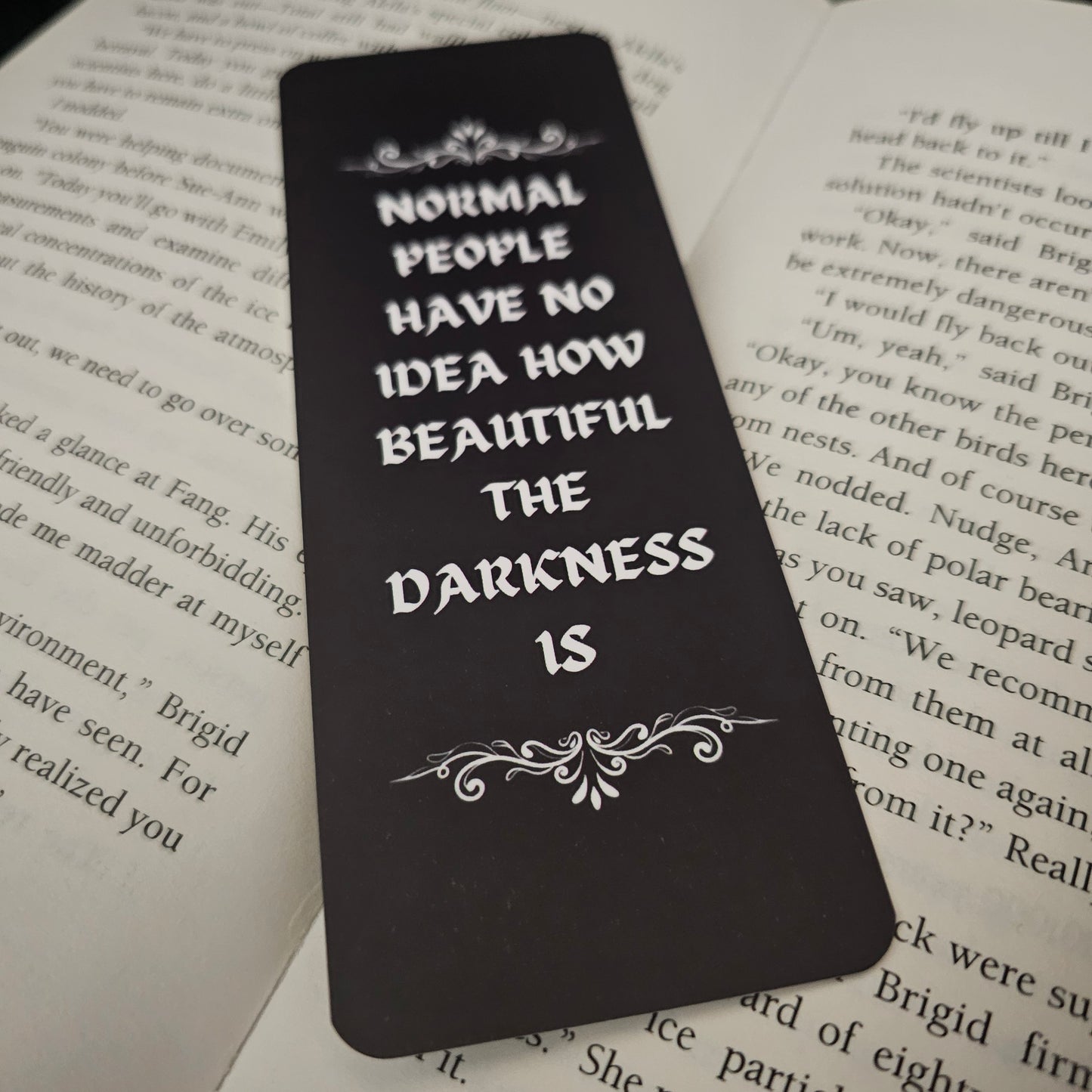 Black bookmark with white text on a book page