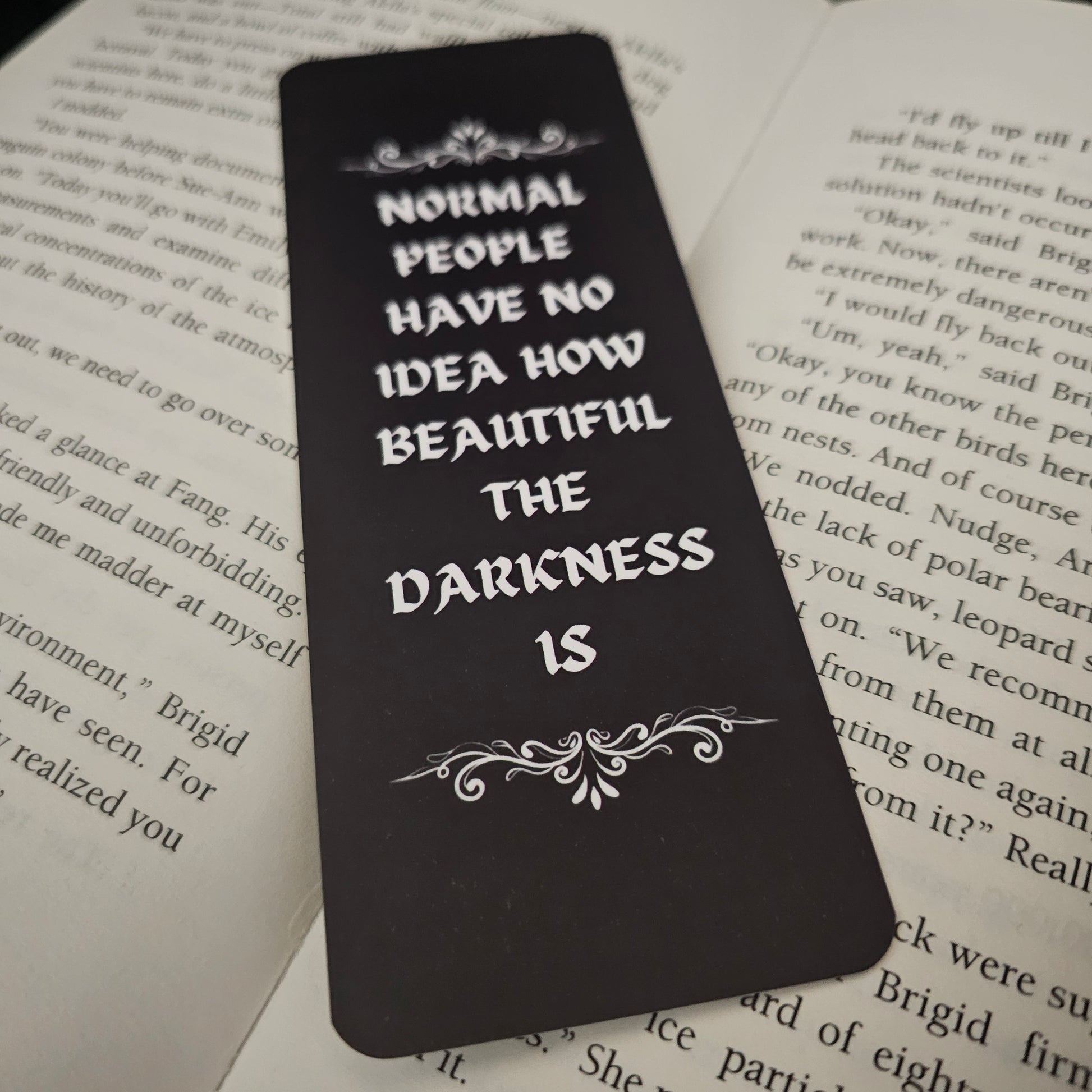 Black bookmark with white text on a book page