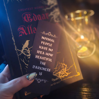 Book and bookmark featuring a quote, held by a hand, against a warm background.