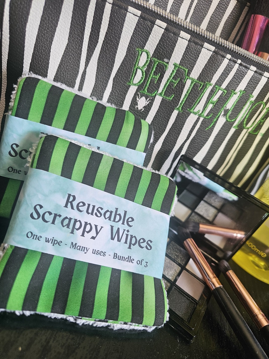 Reusable scrappy wipes with green and black stripes on a makeup bag background