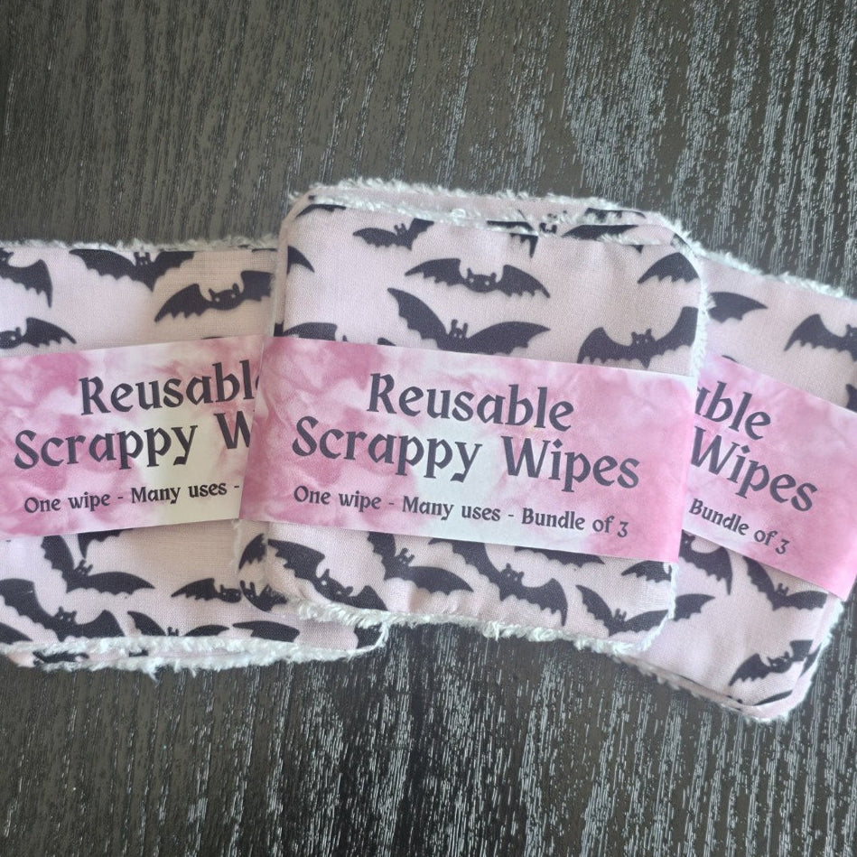 Reusable scrappy wipes with a pink label on a dark surface