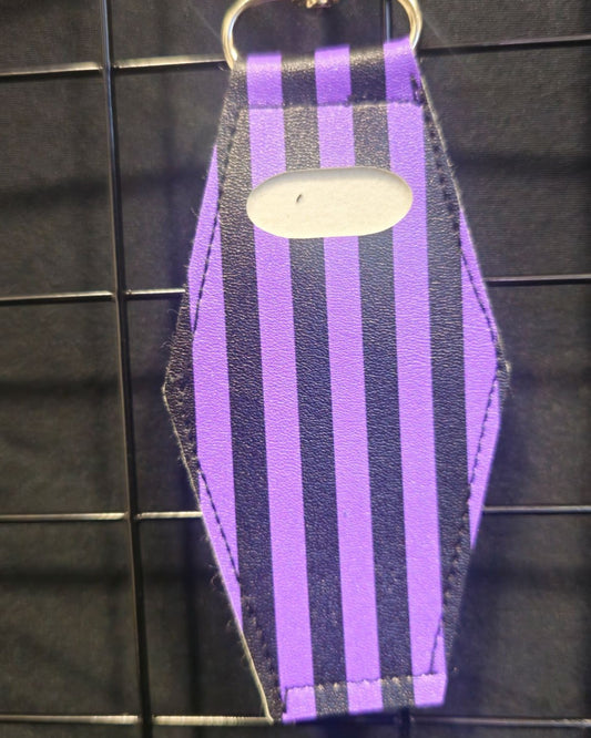 Coffin-shaped lip gloss holder keychain in purple pinstripe print leatherette with stainless steel lobster clasp.