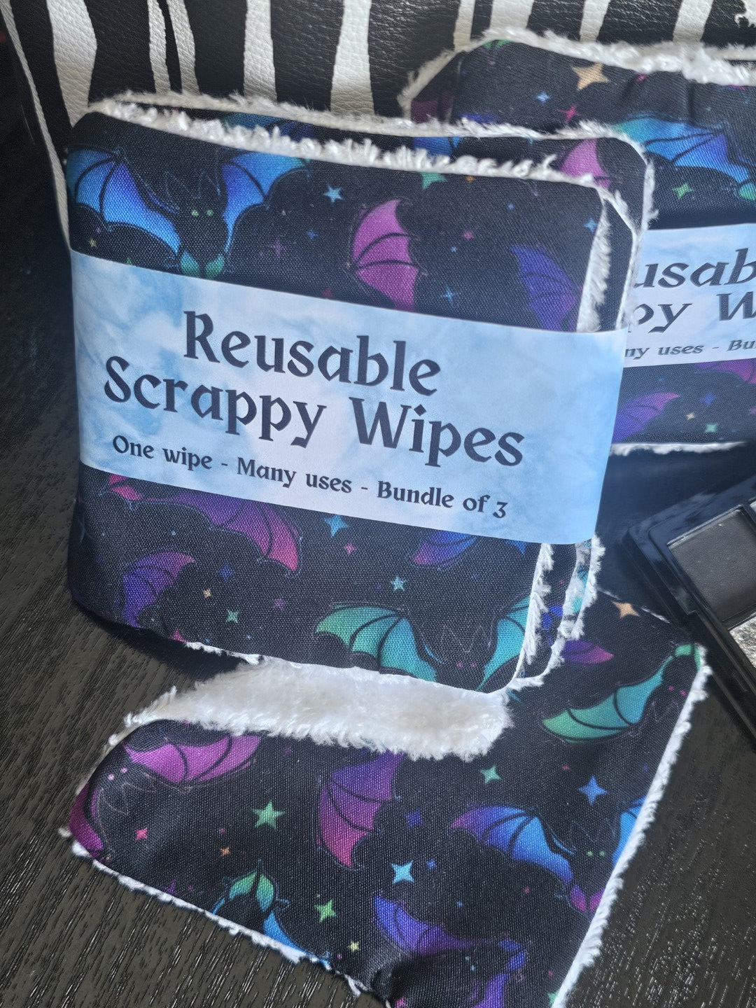 Reusable scrappy wipes with a label on a dark surface
