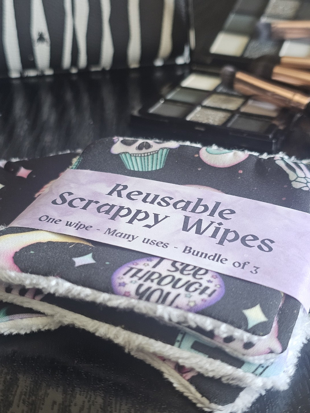 Reusable scrappy wipes with a colorful design and text on a textured surface.