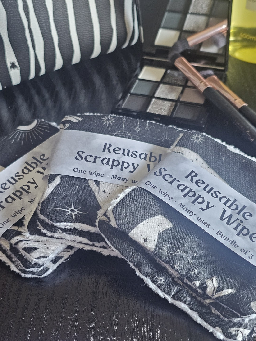 Reusable scrappy wipes with a black and white design on a dark surface
