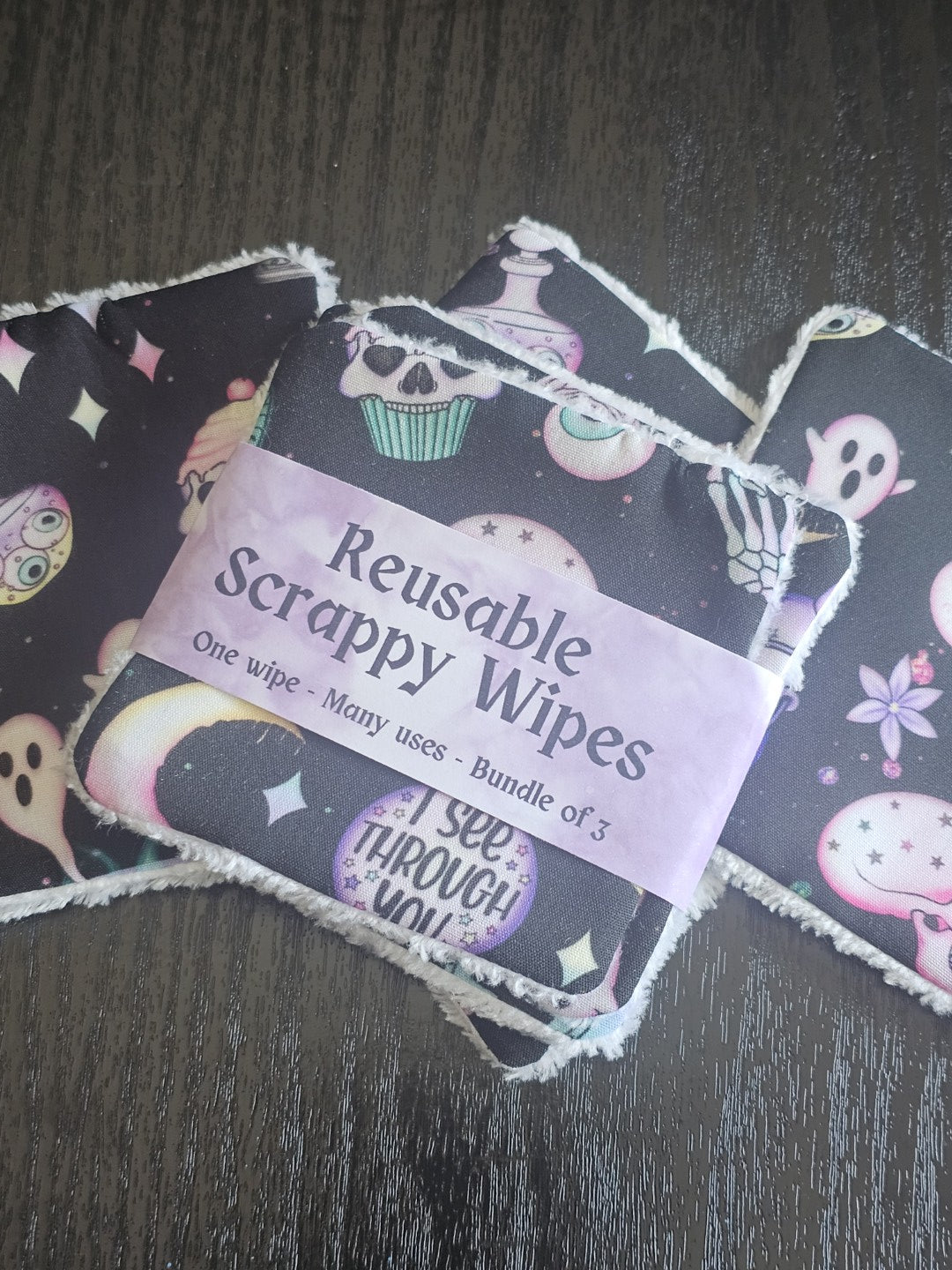 Reusable scrappy wipes with a visible brand label on a dark wooden surface