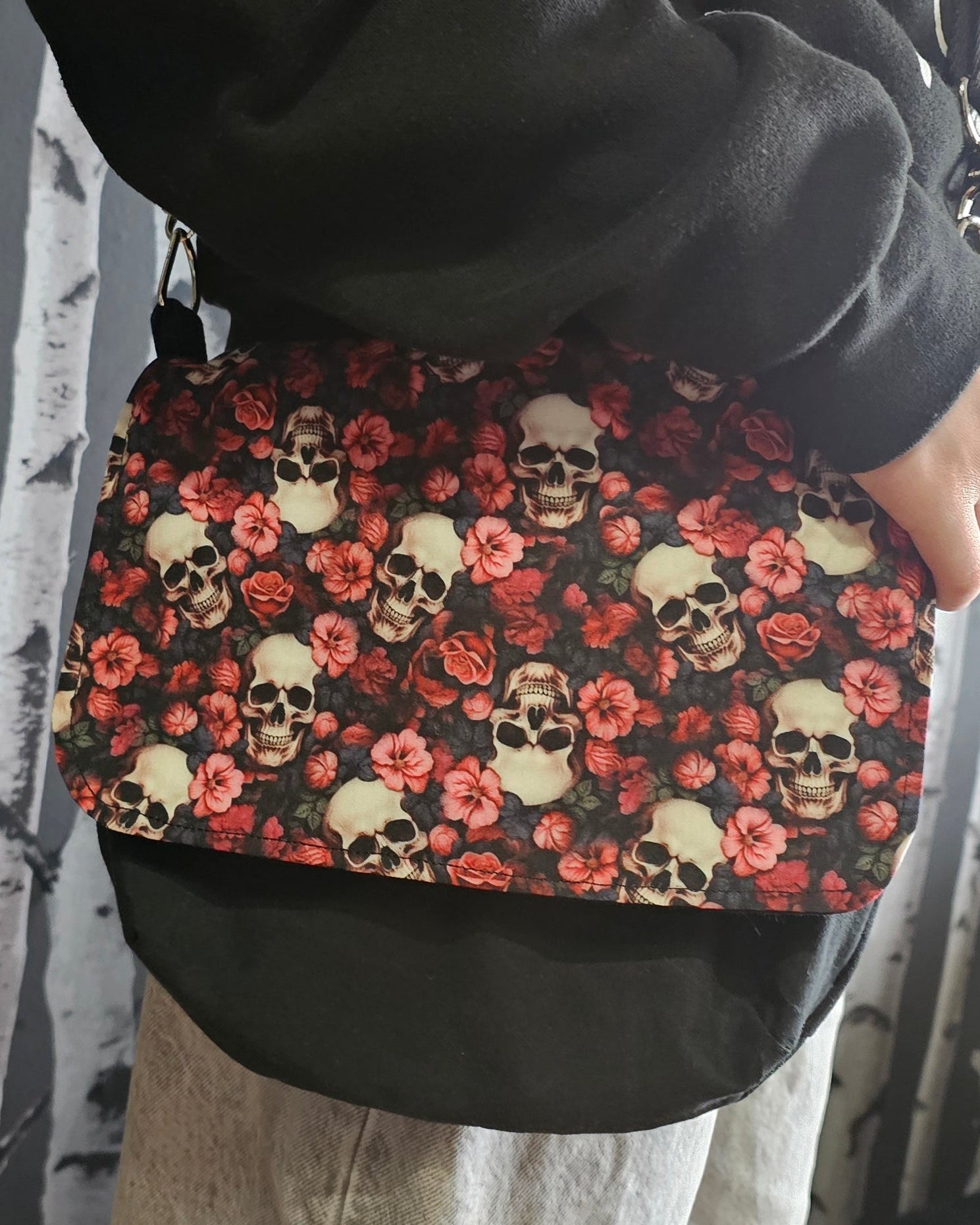 Person wearing a skull & roses patterned crossbody bag 