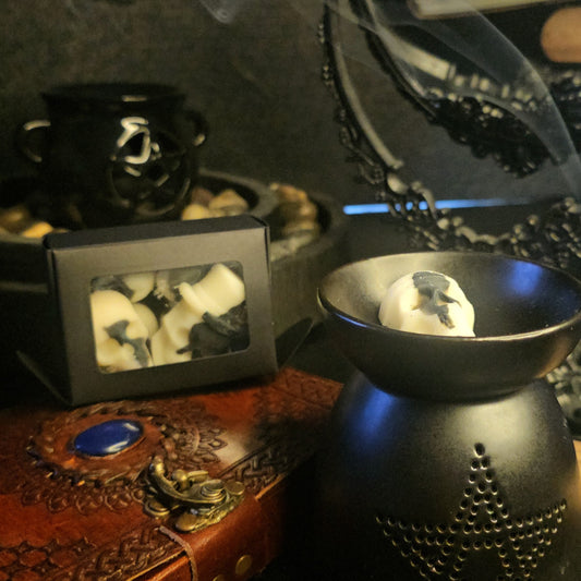 Black textured oil burner with decorative items on a dark background