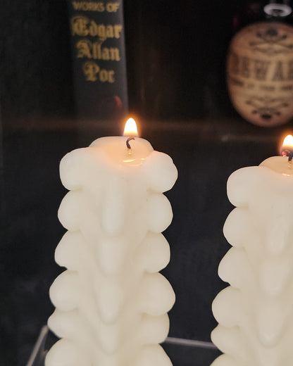 Close up image of a lit Spine shaped candle 