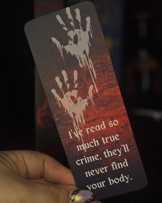 A bookmark with a blood-red background featuring handprint illustrations and the text 'I've read so much true crime, they'll never find your body.'.