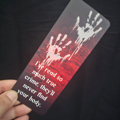 A bookmark with a blood-red background featuring handprint illustrations and the text 'I've read so much true crime, they'll never find your body.'