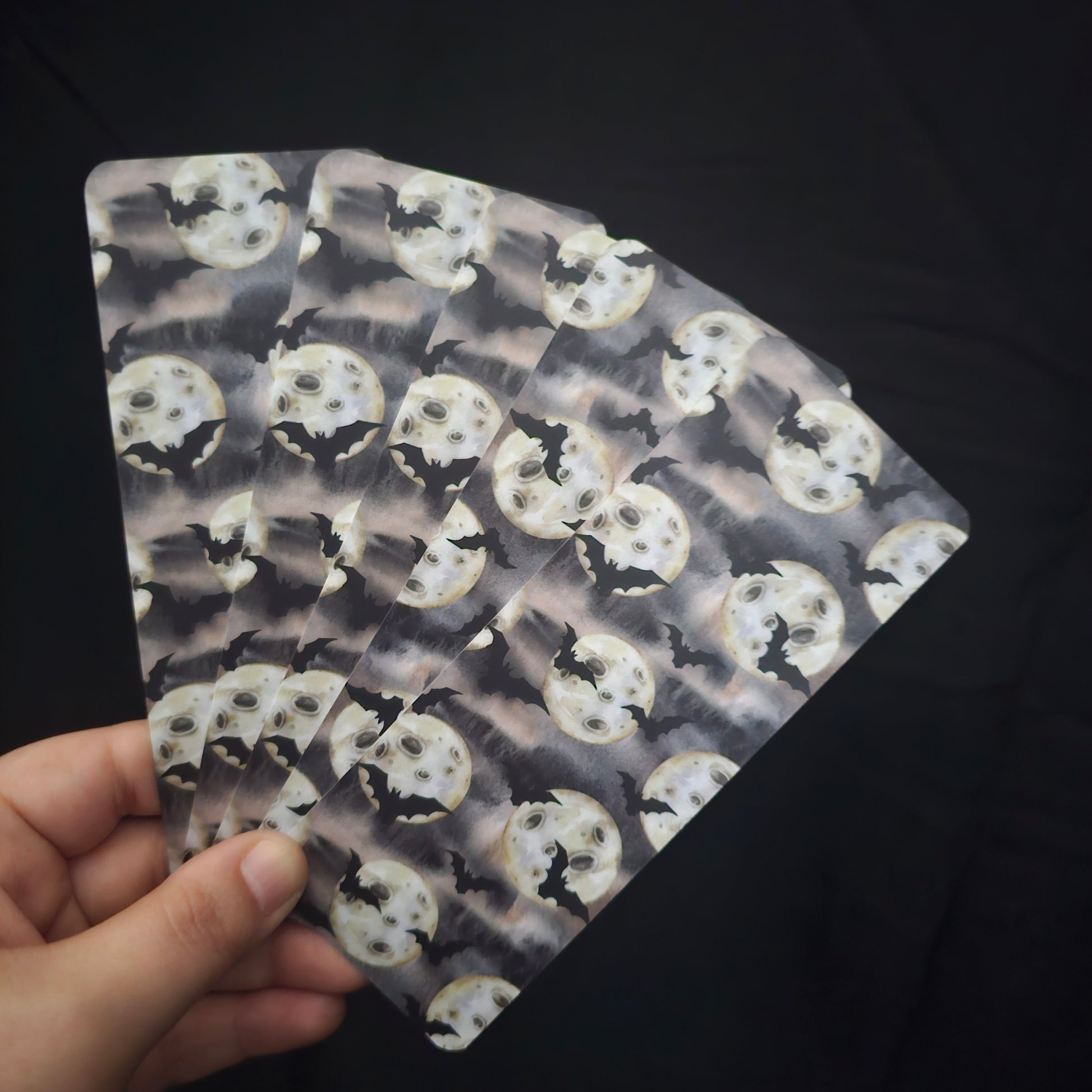 A fan of 5 bookmarks, with a bat and moon pattern 