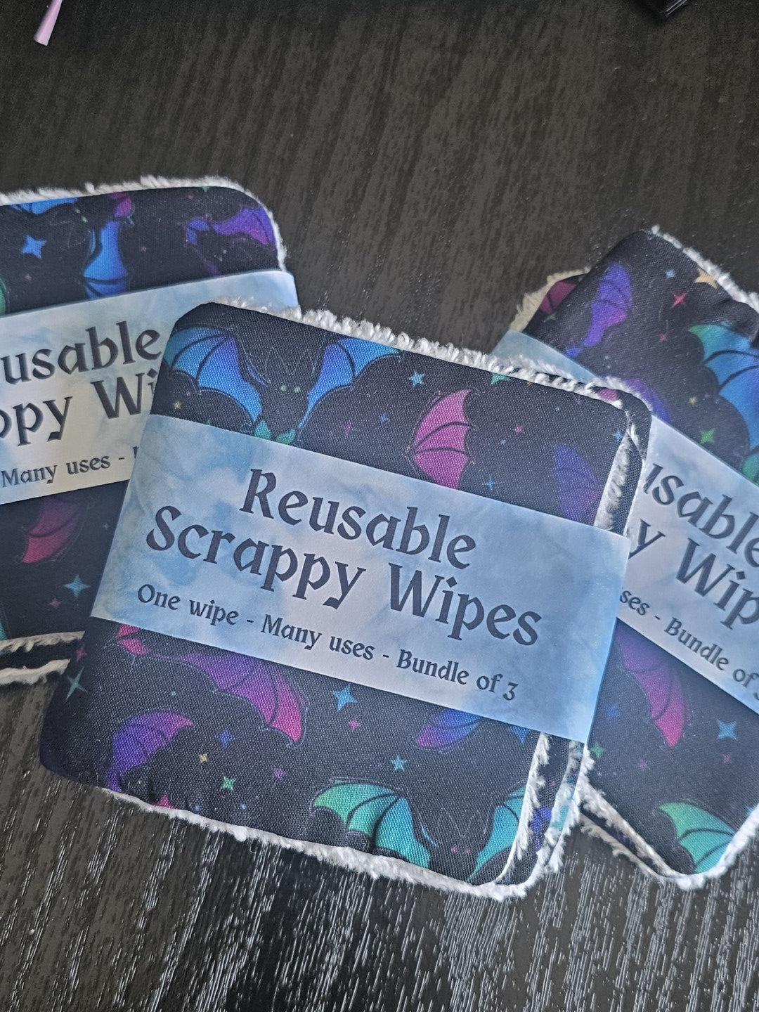 Reusable scrappy wipes with labels on a dark surface