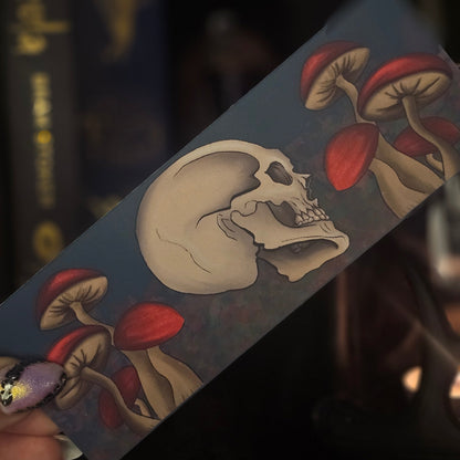 bookmark design with skull and red mushrooms on a dark background