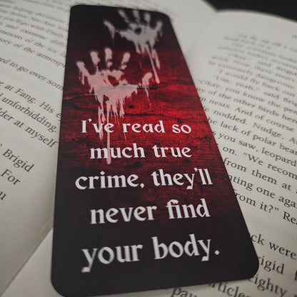 A bookmark with a blood-red background featuring handprint illustrations and the text 'I've read so much true crime, they'll never find your body.'.